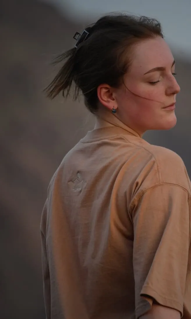 The Empty Quarter tee in profile as the light drops over the mountains. Female model wears M in the Oversized fit.